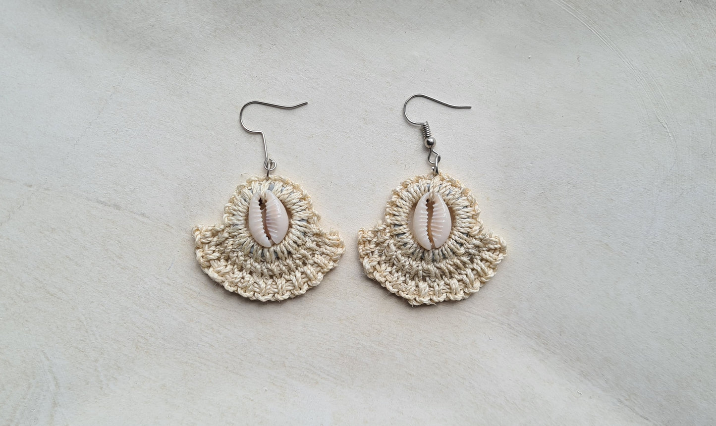 Pair of Cream patterned Sepik Cowrie earrings with shell accents on a light background, Front view