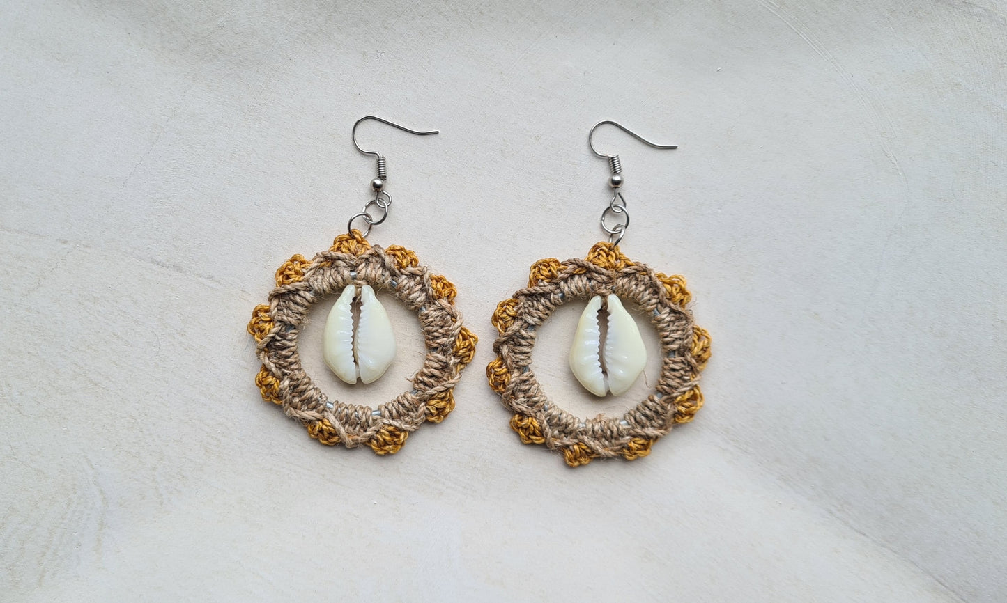 Pair of Pastel Orange patterned Sepik Cowrie earrings with shell accents on a light background, Front view