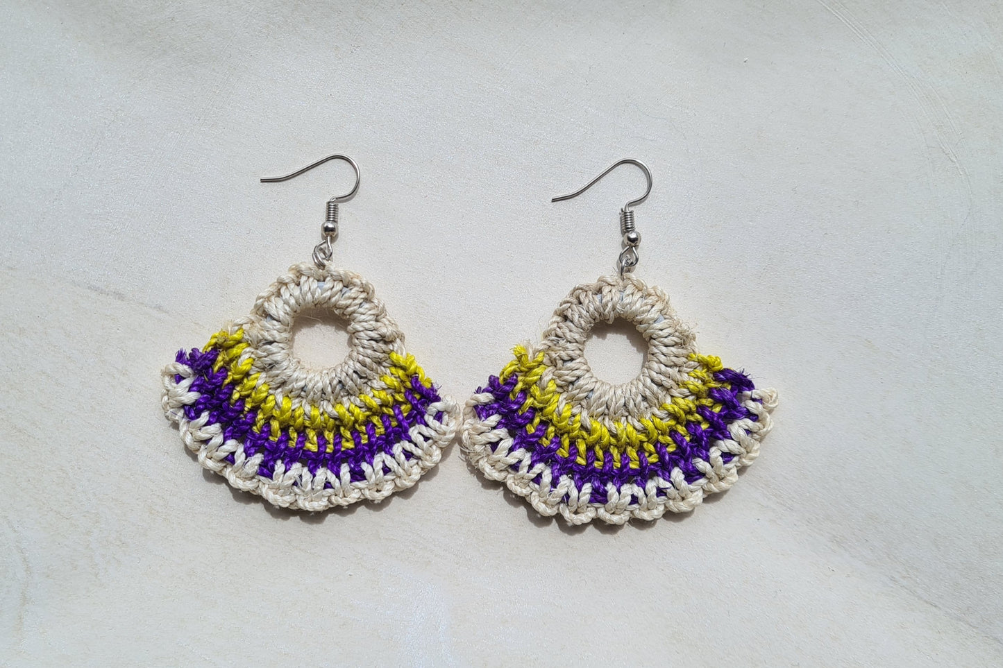 Pair of Nambis patterned Sepik Handwoven earrings on a light background, Front view