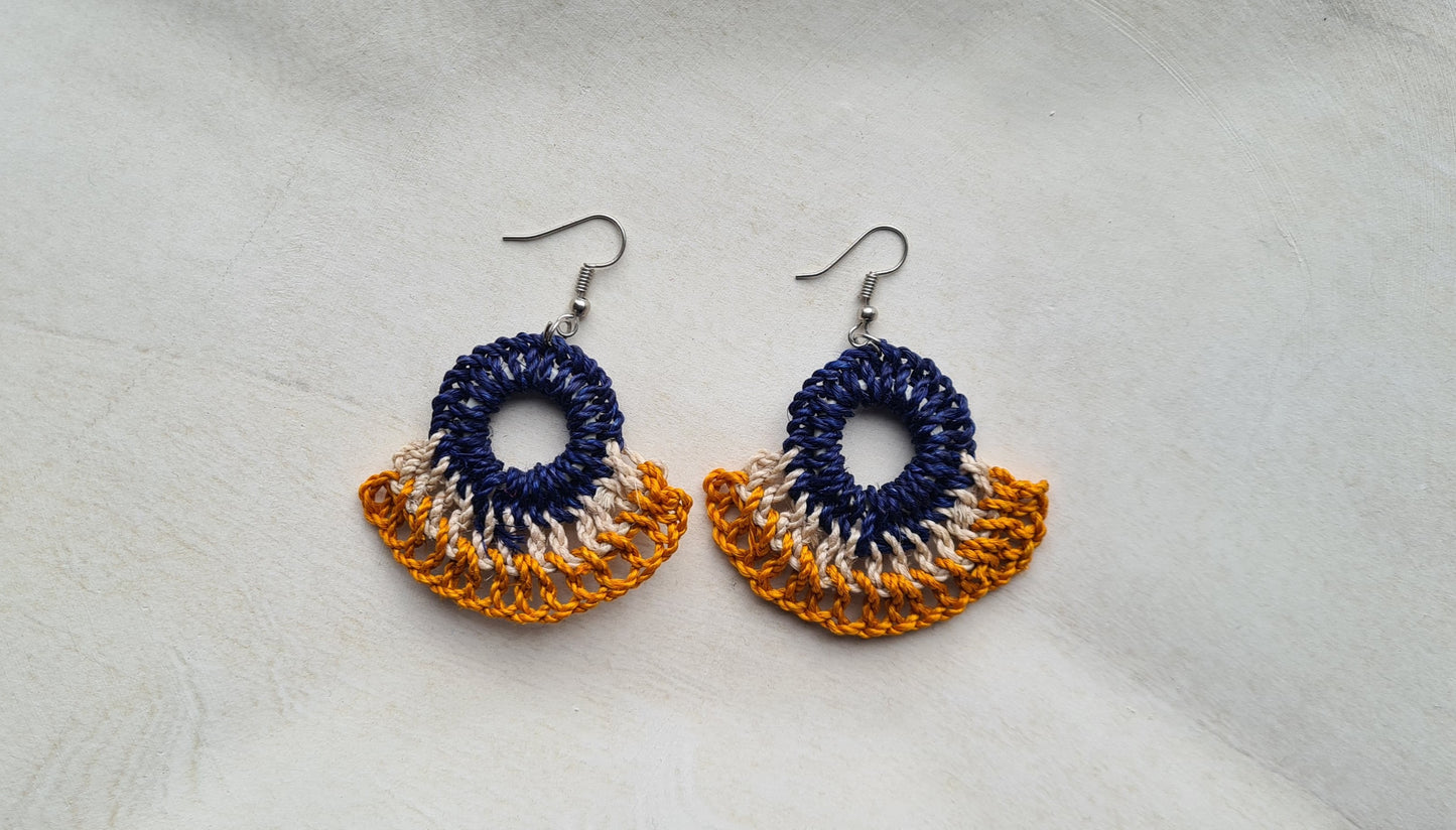 Pair of Niu Ailan patterned Sepik Handwoven earrings on a light background, Front view