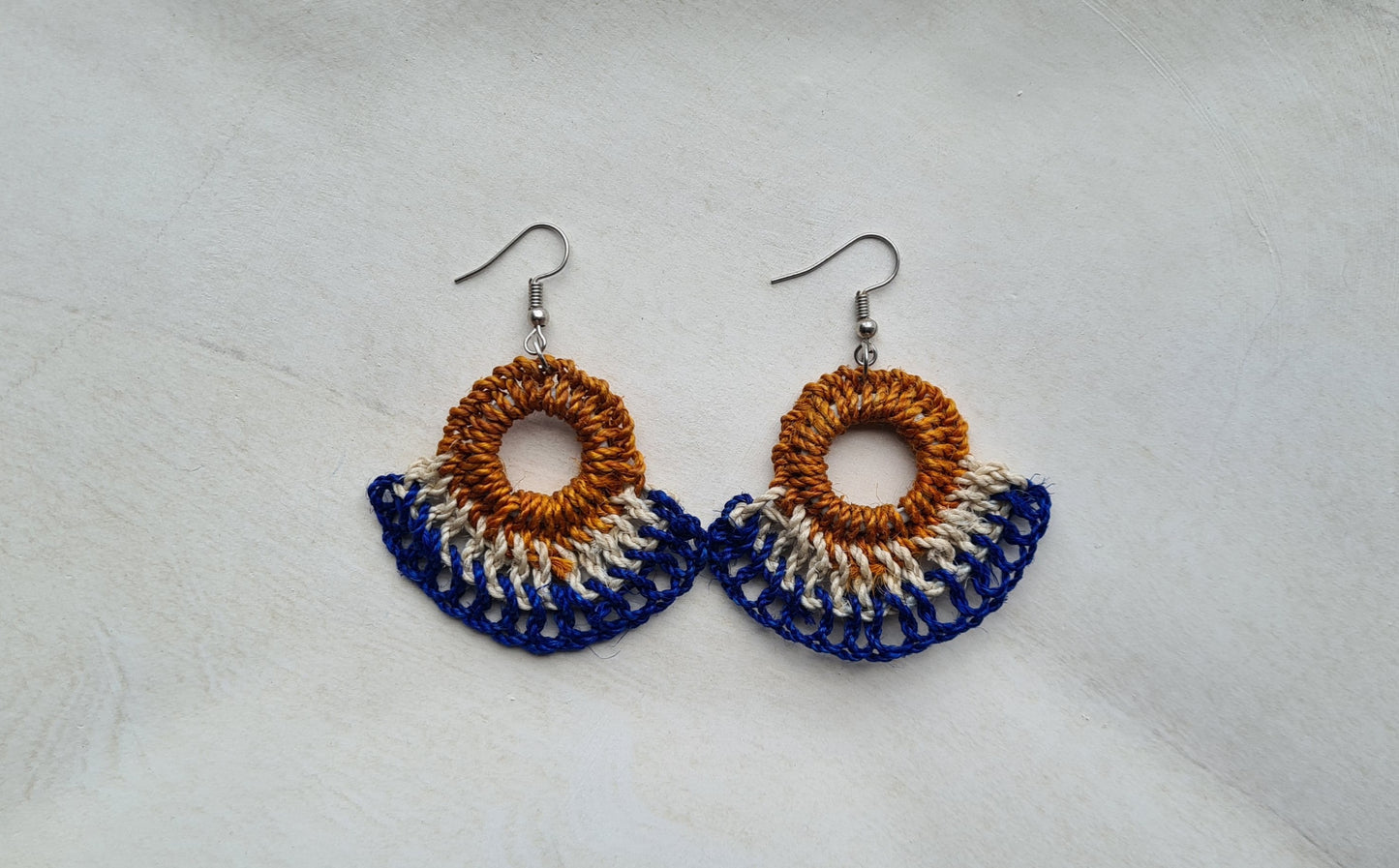 Pair of Sandaun patterned Sepik Handwoven earrings on a light background, Front view