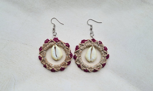 Pair of Magenta patterned Sepik Cowrie earrings with shell accents on a light background, Front view