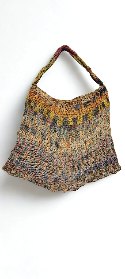 Handmade Natural Fibre Tulip Bilum Bag with Rainbow pattern on light background, Flat Lay Front view