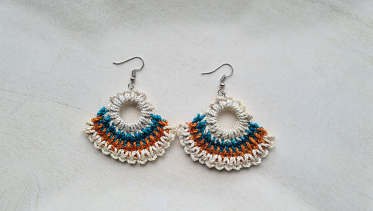 Pair of Kanu patterned Sepik Handwoven earrings on a light background, Front view