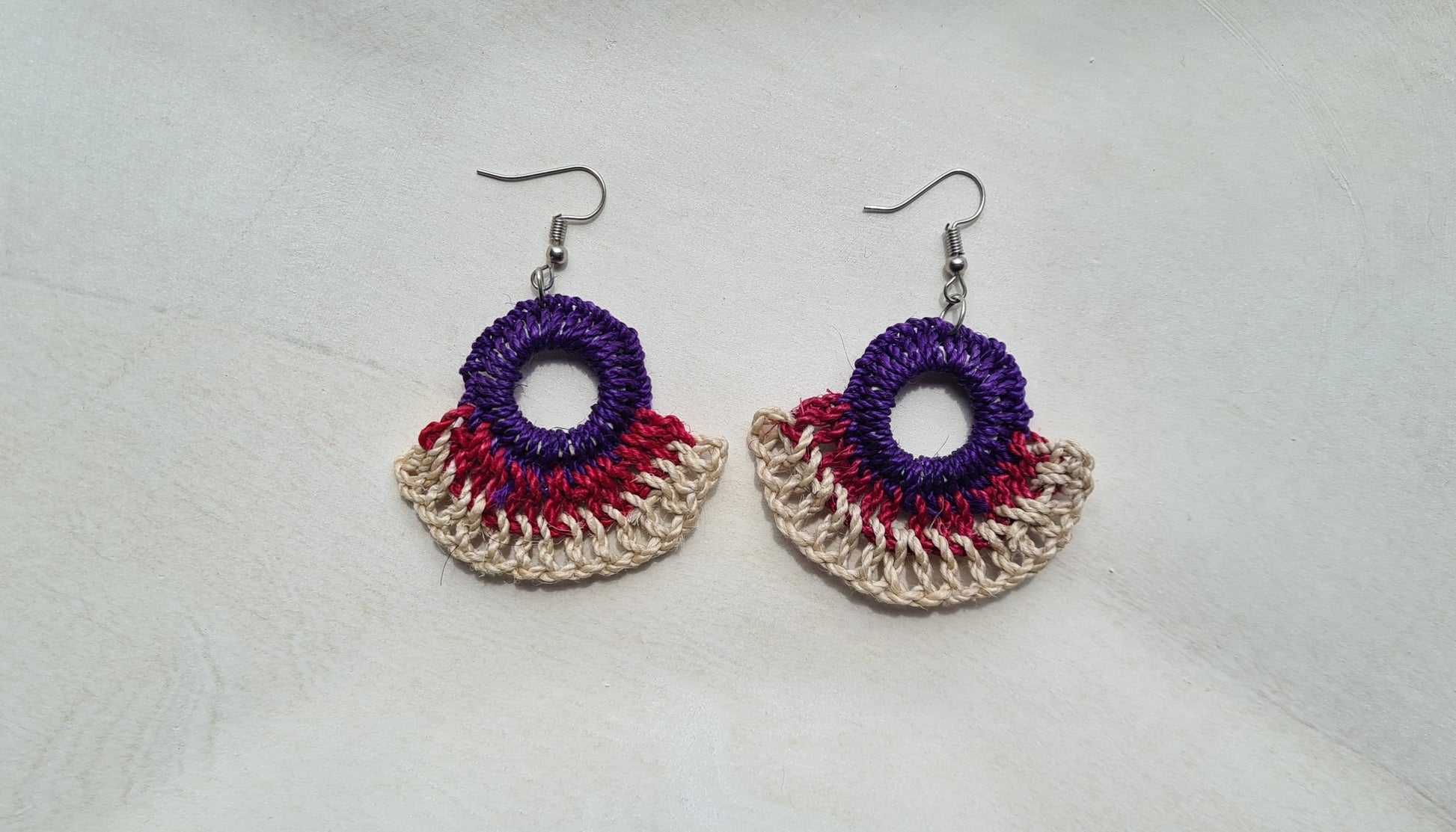 Pair of Midnight patterned Sepik Handwoven earrings on a light background, Front view