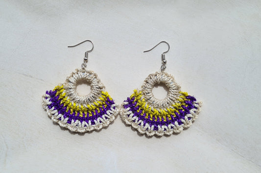 Pair of Nambis patterned Sepik Handwoven earrings on a light background, Front view