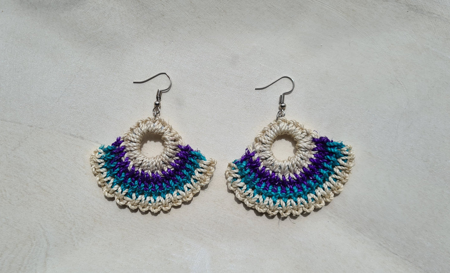 Pair of Solwara patterned Sepik Handwoven earrings on a light background, Front view