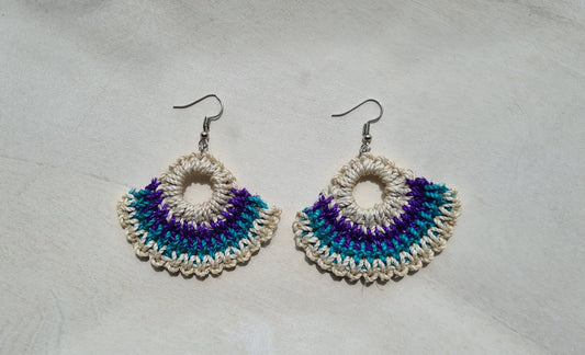 Pair of Solwara patterned Sepik Handwoven earrings on a light background, Front view